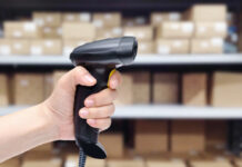 Nooit meer fouten bij voorraadbeheer? Ontdek de kracht van barcodescanners Iemand houdt barcode scanner in hand voor stelling met dozen